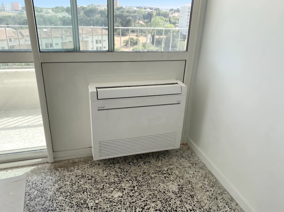 Salon moderne avec climatiseur mural et télécommande au premier plan